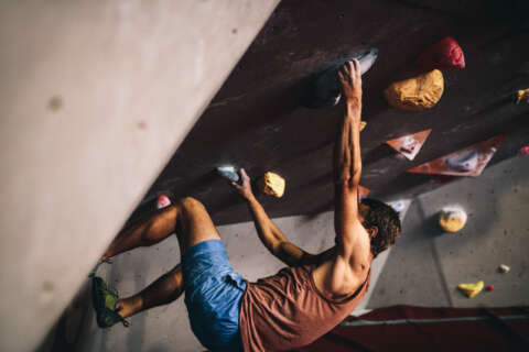 Bouldern: Ein Mann klettert in der Indoor-Halle