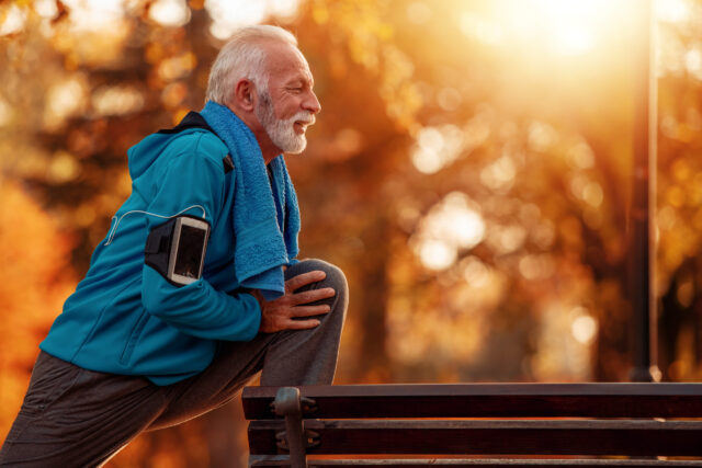 Training fürs Immunsystem: Ein älterer Herr bei Stretching-Übungen im Park während des Herbst