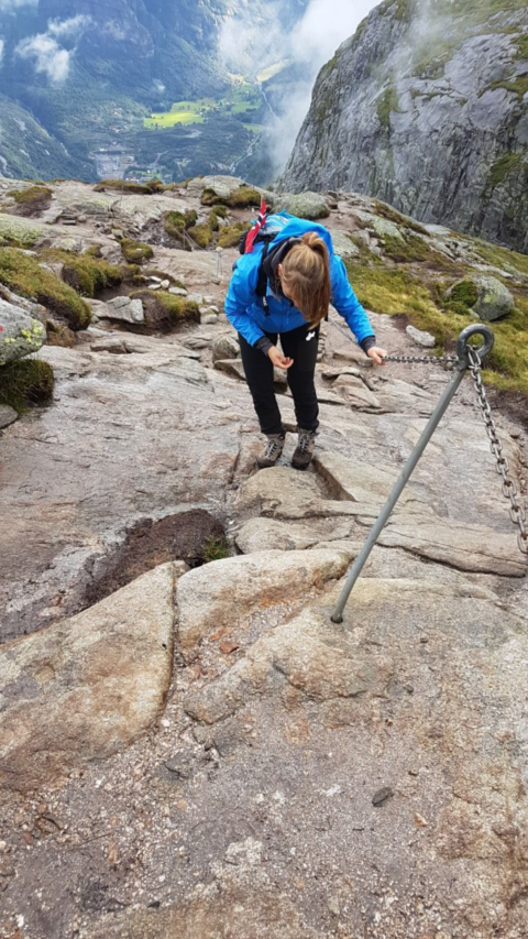 Monika klettert die Felswand am Stahlseil auf dem Weg zum Kjeragbolten hoch