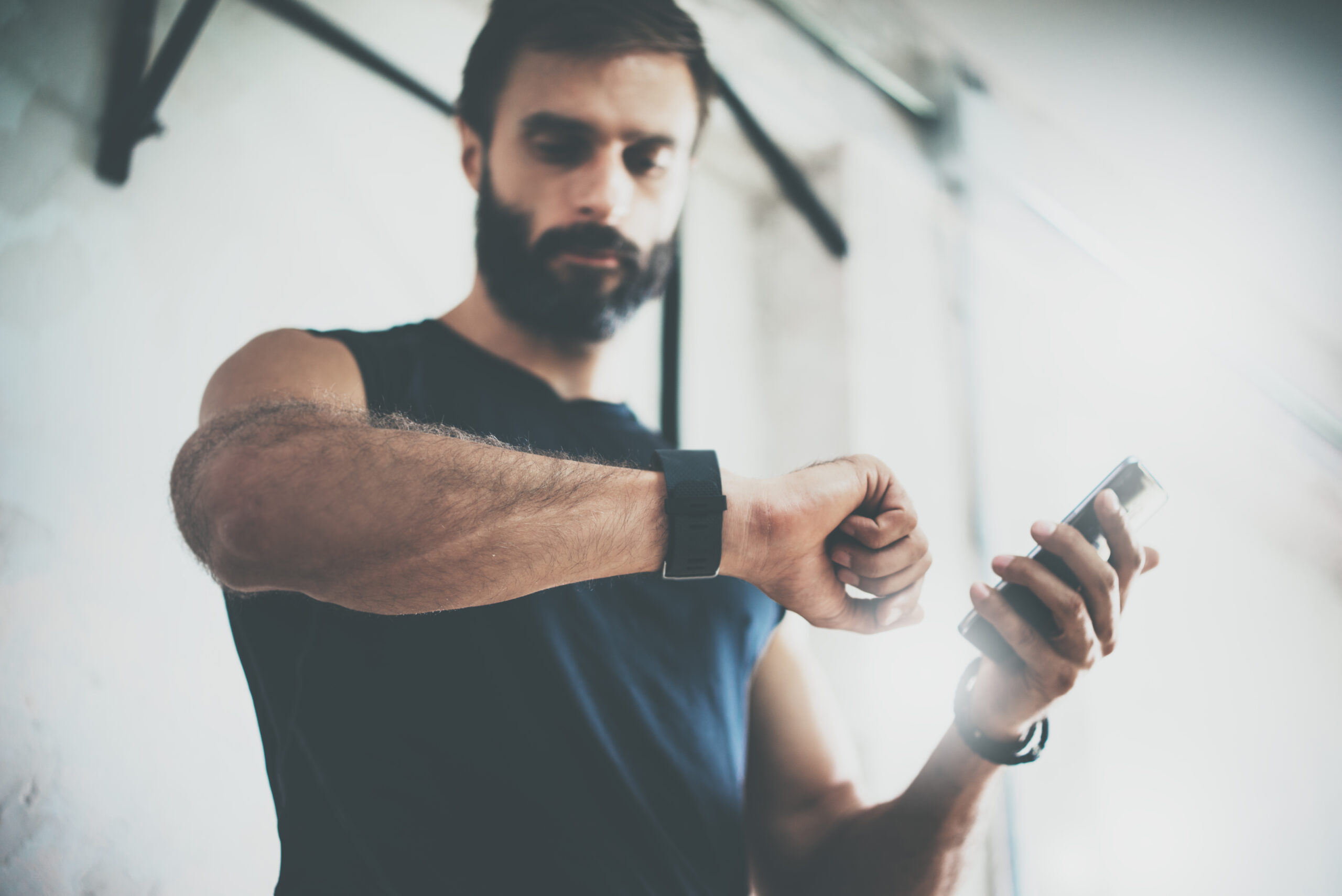 Mann mit Bart checkt Smart-Watch nach Workout