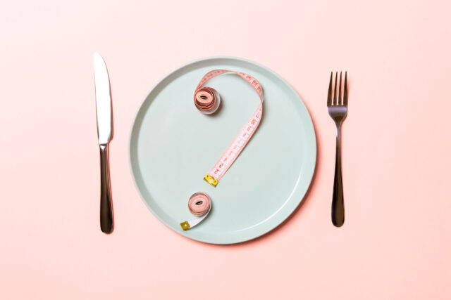 Leptin: Fragezeichen aus rosa Maßbändern auf einem hellblauen Teller