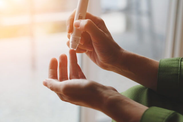 Diabetes: Eine Frau pr&uuml;ft ihren Blutzuckerwert mit einem Messger&auml;t am Finger.