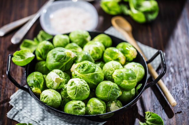frisch zubereiteter Rosenkohl liegt in einer schwarzen Schüssel.