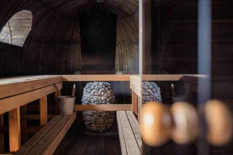 Sauna: Sauna mit offener Glastüre und einem Steinofen