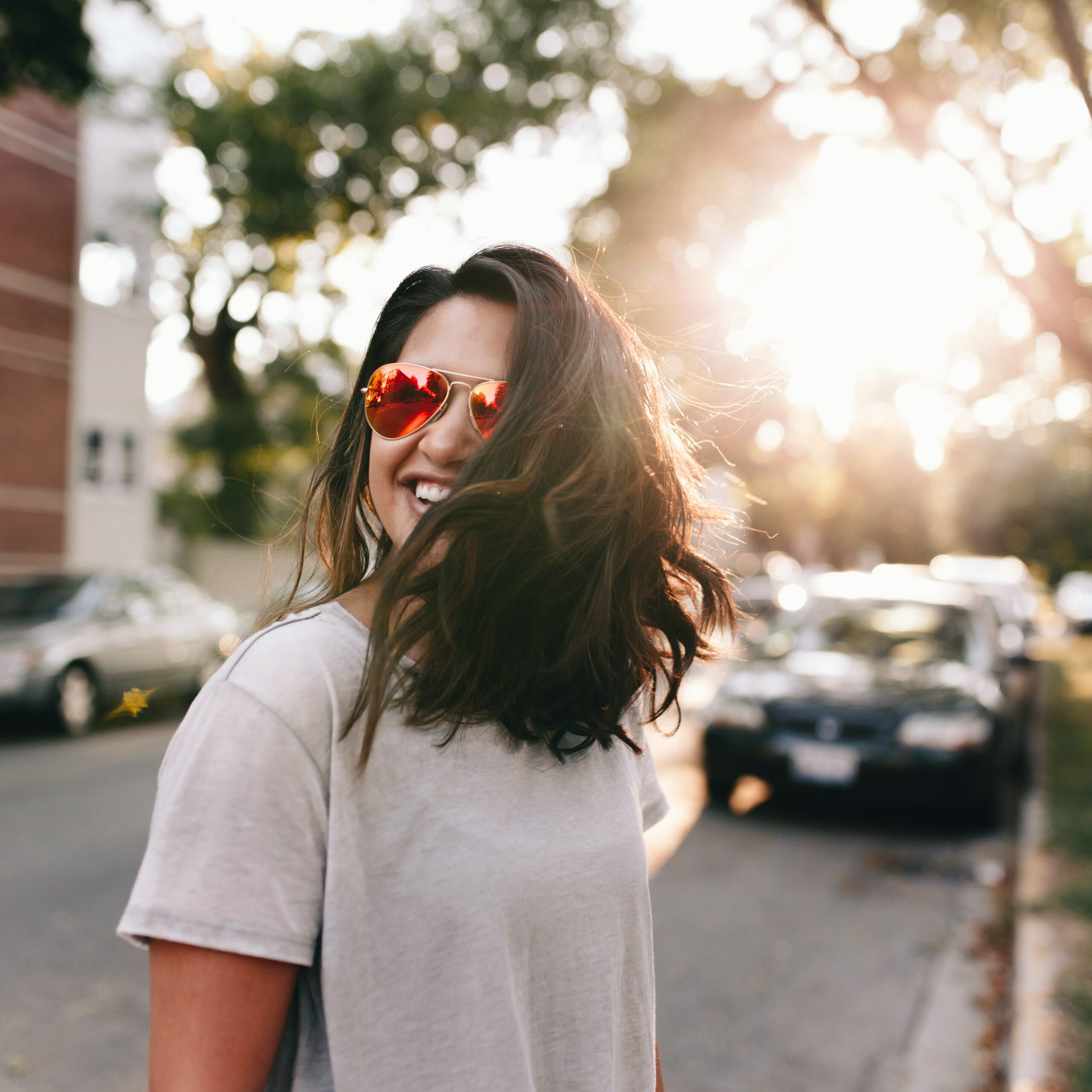 Endlich Frühling: Junge Frau im T-Shirt mit Sonnenbrille