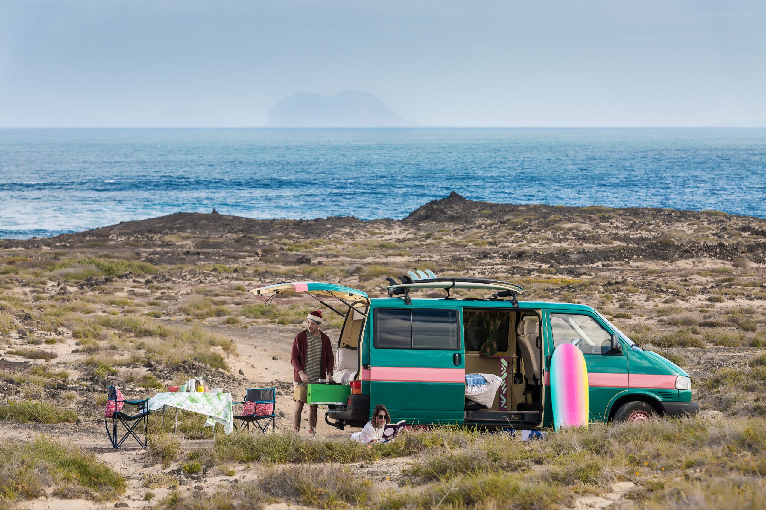 Outdoor-Typ: Ein Mann und eine Frau campen in einem Van an einer Küste