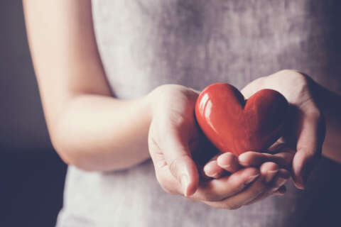 Organspende: Frau hält Herz in beiden Händen.