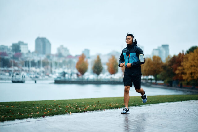 Laufen ist ges&uuml;nder Teil 2: Mann joggt an einem Regentag an einem See