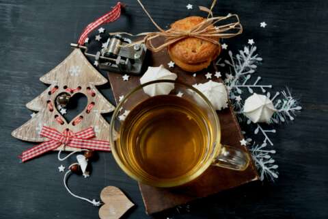 Gesündere Weihnachten: Glastasse mit Tee und weihnachtlichem Gebäck und Deko