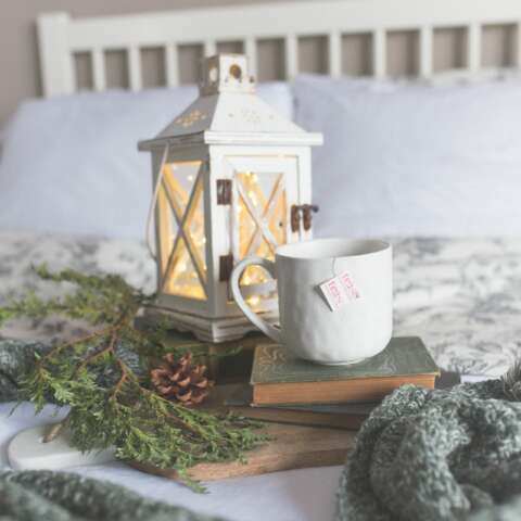 Gesündere Weihnachten : Weiße Tasse mit Tee auf einem Buch