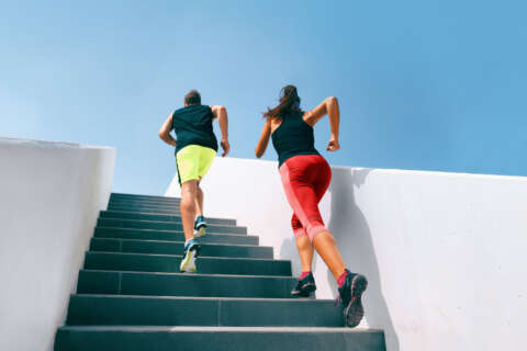 OUTDOOR FITNESS: Läuferpaar rennt eine Treppe hinauf