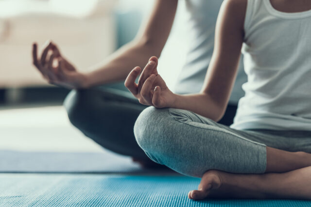 Atmen: M&auml;dchen und Frau machen Yoga im Schneidersitz.
