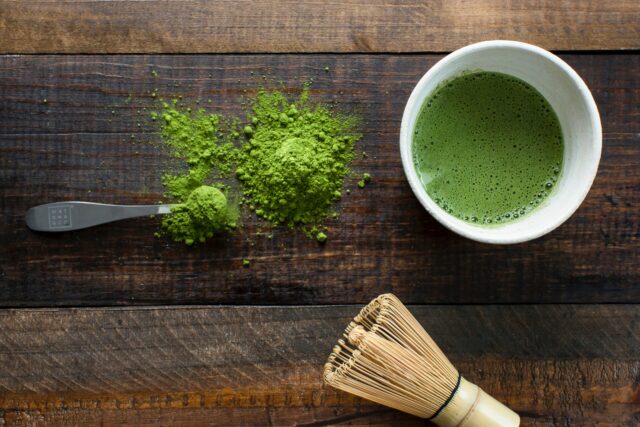 Tee: Gefäß mit grünem Tee und grüner Tee in Pulverform.